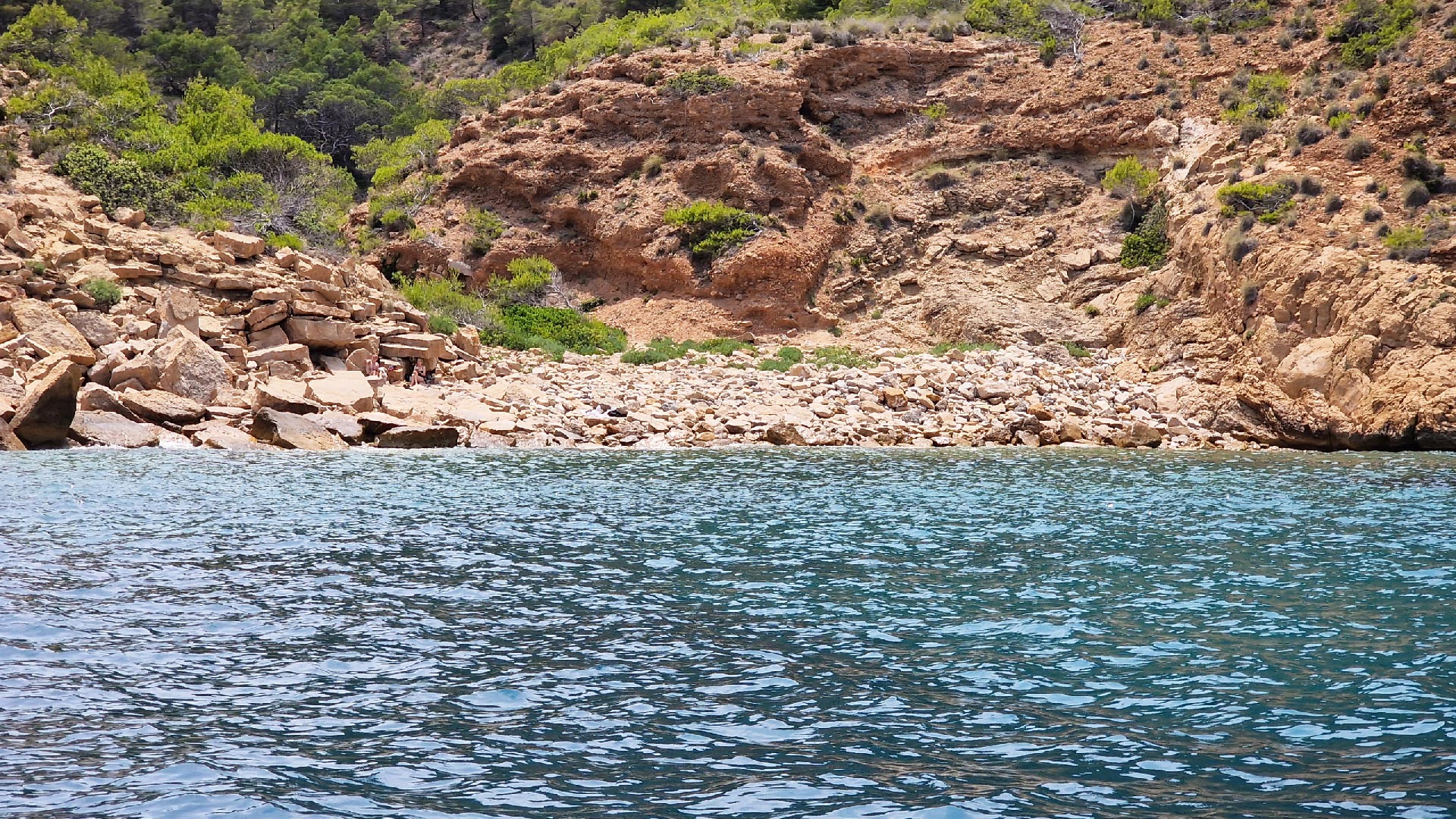 Cala La Mina and rocky coastline seen from the sea